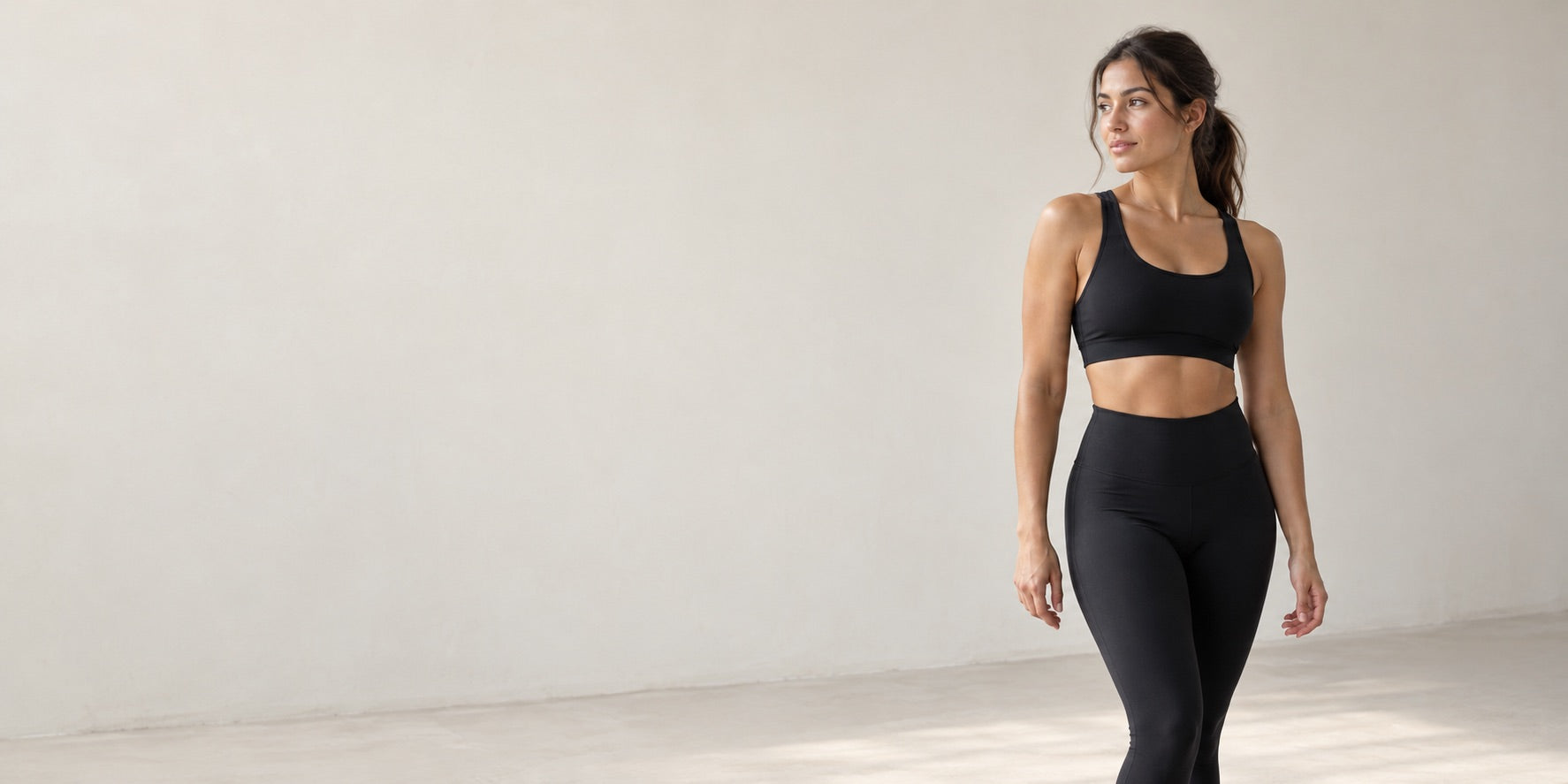 Model wearing a matching activewear set in a bright studio